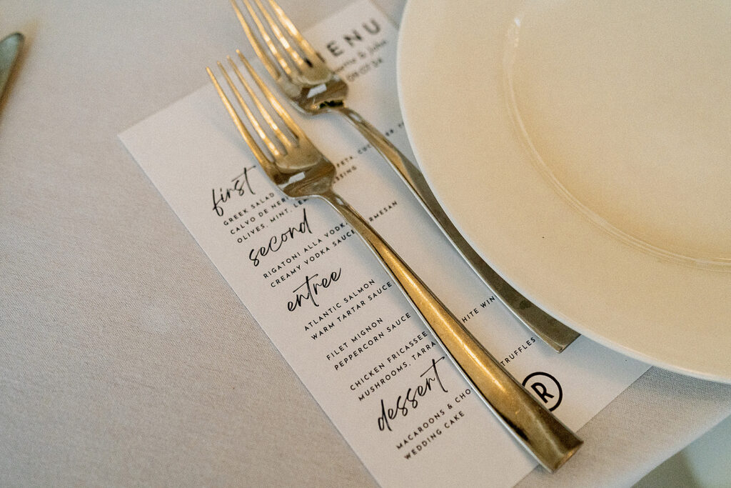 Close-up of wedding decor details, including personalized place cards and floral arrangements at the reception.