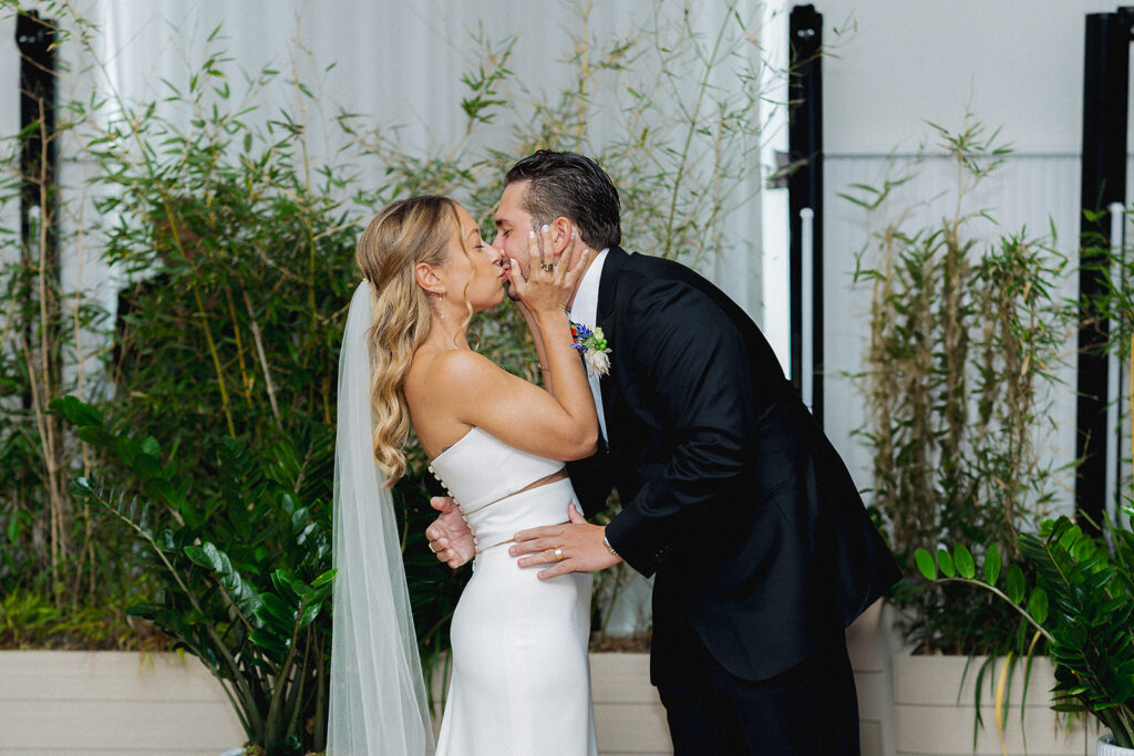 Newlyweds sharing their first kiss as husband and wife during their ceremony at the Rockaway Hotel.